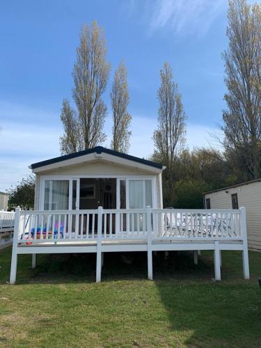 a large white porch with a white fence at DaisyChain Getaways The perfect place to Stay Play and Getaway in East Mersea