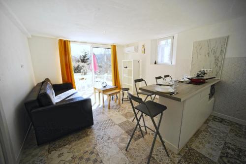 a living room with a kitchen and a table with a chair at Les quatre chênes in Bauduen