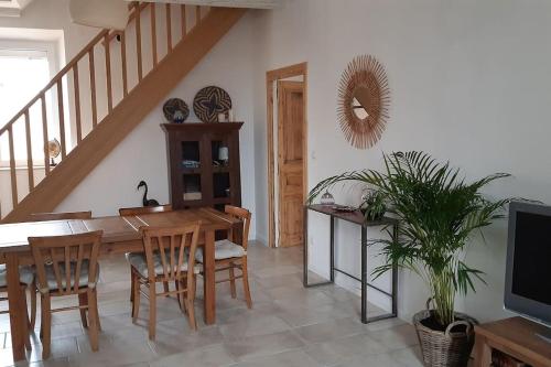 een eetkamer met een tafel en een tv bij Le logis du moulin, à 800m de la cité médiévale in Carcassonne