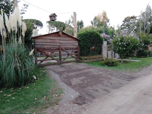 a wooden barn with a gate in a yard at Cabañas Monje in Tandil