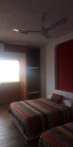 a bedroom with two beds and a ceiling fan at HOTEL VILLAS XAIBA in Puerto Escondido