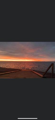 a view of the ocean at sunset from a pier at DaisyChain Getaways The perfect place to Stay Play and Getaway in East Mersea
