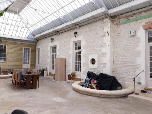Cette grande chambre dispose d'une table et d'un plafond en verre. dans l'établissement La Maison de Maître, à Sainte-Soulle