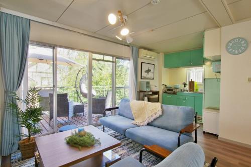a living room with a blue couch and a table at VILLENT Atagawa Terrace - Vacation STAY 28115v in Okawa
