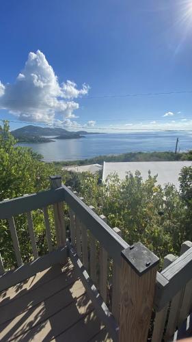 a bench on a deck with a view of the water at Virgin Islands Campground in Water Island