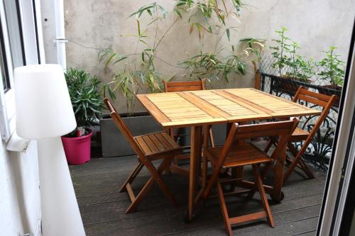 uma mesa de madeira e cadeiras num pátio em Superbe T3 Terrasse Coeur de Paris historique em Paris