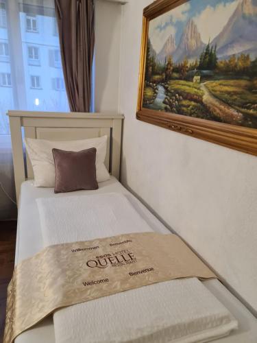 a bed in a room with a painting on the wall at Esos Hotel Quelle in Bad Ragaz