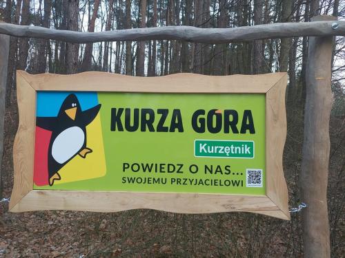 a sign with a penguin on it in the woods at Ranczo u Wróbla in Słupnica