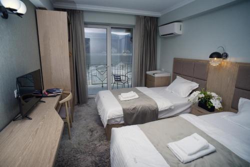 a hotel room with two beds and a balcony at Onyx in Eşelniţa