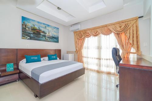 a bedroom with a bed and a desk and a window at Ayenda Yubarta in Buenaventura