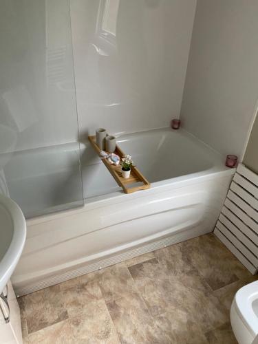 bagno con vasca bianca e servizi igienici di DaisyChain Getaways The perfect place to Stay Play and Getaway a East Mersea