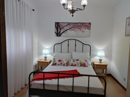 a bedroom with a bed with two nightstands and two lamps at Casa Corredoura in Ponte de Lima