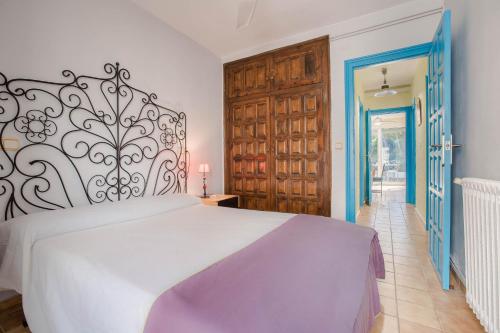 a bedroom with a large white bed and blue doors at Casa Rosana by MarCalma in Miami Platja