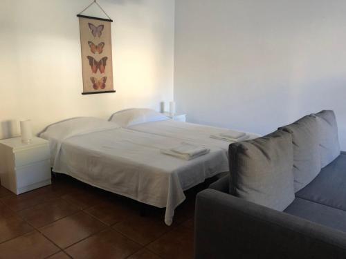 1 dormitorio con cama blanca y sofá en Velasmar II, en Velas