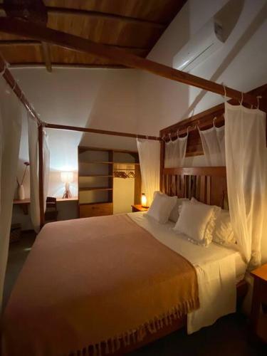 a bedroom with a large bed with white pillows at La belle de jour in Fortim
