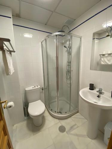 y baño con ducha, aseo y lavamanos. en Bj. A Apartamentos Arguiñan en Córdoba