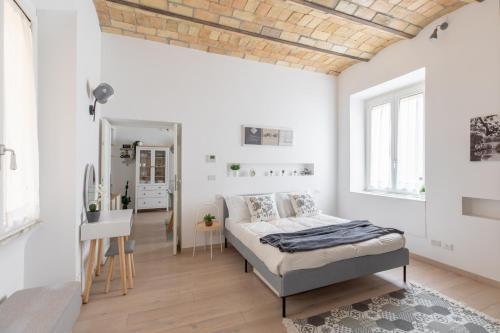 a white bedroom with a bed and a desk at iFlat Saint Peter Bright Apartment in Rome