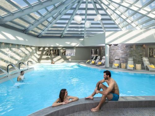 a group of people sitting in a swimming pool at Belvilla by OYO Vent in Livigno