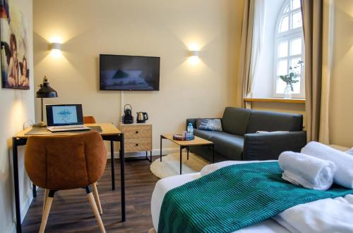 a living room with a bed and a laptop on a desk at HOMELY STAY Studio 3 in Munich