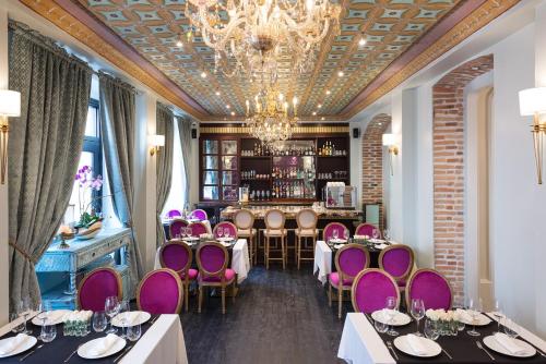 d'un restaurant avec des tables et des chaises pourpres ainsi que d'un bar. dans l'établissement Itza Hotel Boutique Internacional, à Cuenca