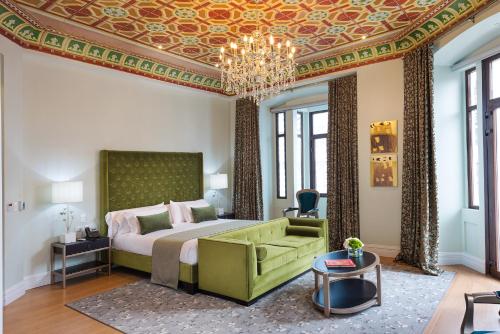 um quarto com uma cama grande e um lustre em Itza Hotel Boutique Internacional em Cuenca