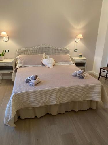 sypialnia z łóżkiem z 2 lalkami w obiekcie Tra mare e lago w mieście Torre Faro