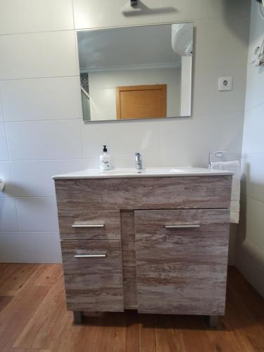 uma casa de banho com um lavatório de madeira e um espelho em PORTILLO - LA COLINA em Arnuero