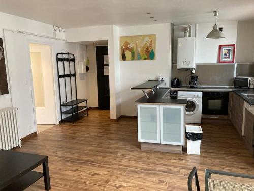 une cuisine avec des armoires blanches et un plancher en bois dans l'établissement Appartement spacieux hyper centre Secteur Liberté, à Brest
