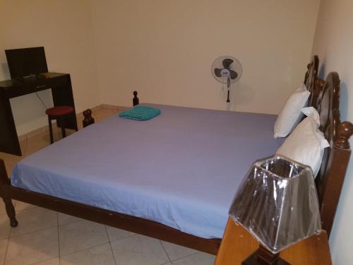 a bedroom with a bed with a plastic bag on it at chez albino guest house in São Filipe