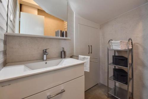 een witte keuken met een wastafel en een handdoekenrek bij Apartman Bora 1 in Novalja