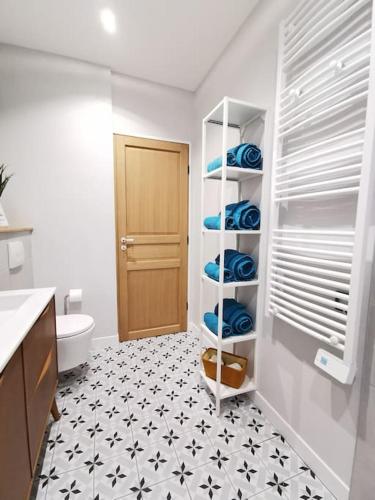 La salle de bains est pourvue de toilettes et d'une étagère avec des serviettes. dans l'établissement Les Bulles d'Aÿ - Terrasse, à Ay