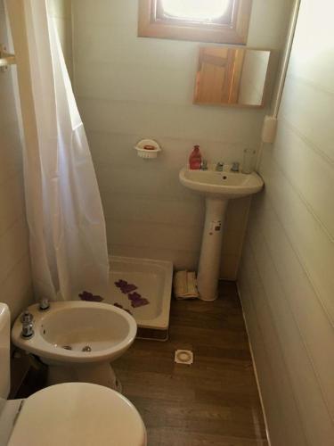 a bathroom with a toilet and a sink at Chacra Mandala in Gualeguay