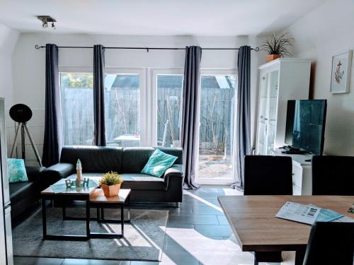 uma sala de estar com um sofá e uma mesa em Dat lütte Strandhuus em Cuxhaven
