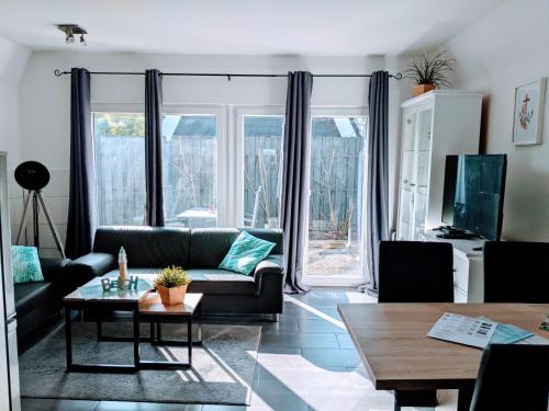 a living room with a couch and a table at Dat lütte Strandhuus in Cuxhaven
