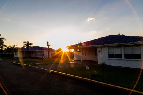 a house with the sun setting behind it at Hotel Palma Verde in Armenia