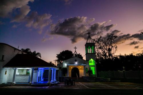 a church with green lights in front of a tower at Hotel Palma Verde in Armenia