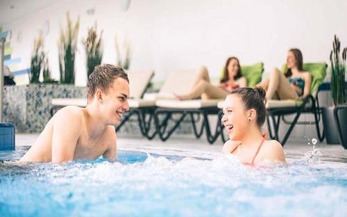 a man and a girl in a swimming pool at Ferienhaus Nr 12A3, Feriendorf Hagbügerl, Bayr Wald in Waldmünchen