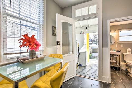 a kitchen and dining room with a glass table and yellow chairs at Uptown NOLA Apt on Magazine Street with Backyard! in New Orleans