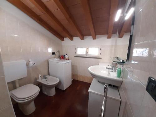 a white bathroom with a toilet and a sink at Appartamento sui tetti di Parma in Parma