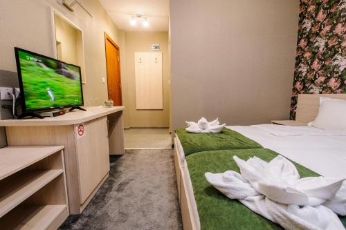 a hotel room with a bed and a flat screen tv at Пиргуля in Miladinowzi