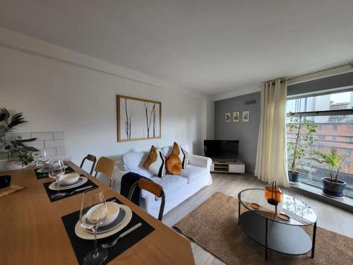 City Centre Snow Hill Apartment (Sleeps 6) في برمنغهام: غرفة معيشة مع أريكة بيضاء وطاولة