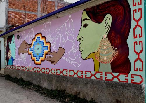 a wall with a painting of a woman on it at Ojo de Luna Teotitlan in Teotitlán del Valle