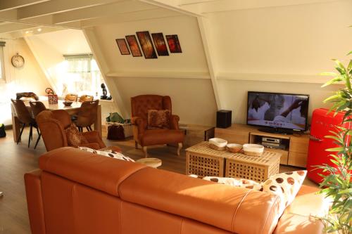 a living room with a couch and a television at Durbuy chalet 90 in Durbuy
