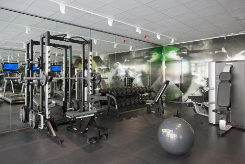 a gym with tread machines and a wall with a mural at Best Western Princess Hotel in Norrköping