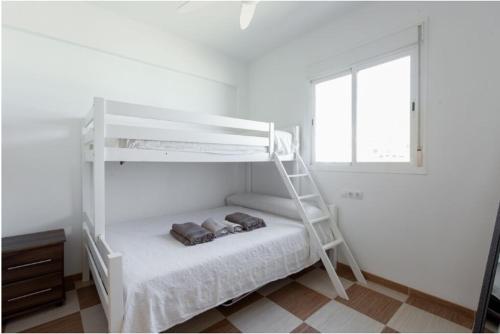 a white bunk bed in a white room with a window at Apartamento, Casa, Chalet Adosado FRENTE AL MAR in Carboneras