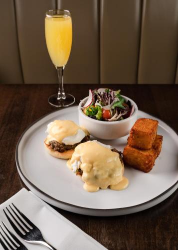 a plate of food with a salad and a glass of orange juice at Century Plaza Hotel in Vancouver