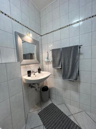 a white bathroom with a sink and a mirror at O&W Ferienzimmer am Nürburgring, Quiddelbach in Quiddelbach