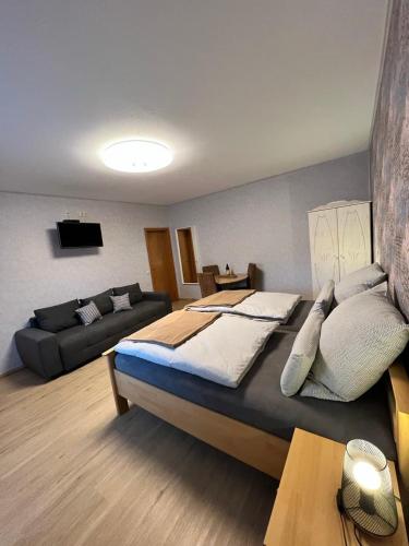 a bedroom with a large bed and a couch at Rooms4ring Privatzimmer am Nürburgring in Quiddelbach