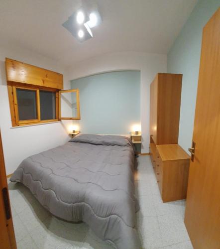a bedroom with a bed and a wooden cabinet at Bellacation in Letojanni