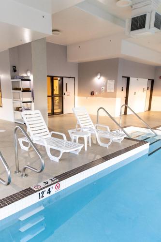 a swimming pool with lounge chairs and a swimming pool at Hotel 11, MOD A Sonesta Collection in Calgary